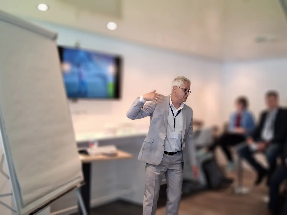 Winfried Schröter am Flipchart vor einer kleinen Gruppe